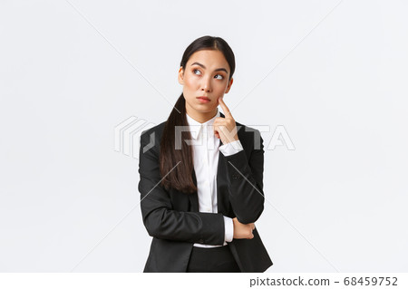 Thoughtful serious-looking asian female manager, office worker in suit thinking about solution, making hard choice, looking away while pondering, standing white background Thoughtful serious-looking asian female manager, office worker in suit thinking about solution, making hard choice, looking away while pondering, standing white background 68459752