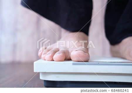 woman's feet on weight scale close up. woman's feet on weight scale close up. 68460241