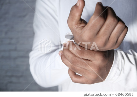Young man in white shirt suffering wrist pain, close up Young man in white shirt suffering wrist pain, close up 68460595