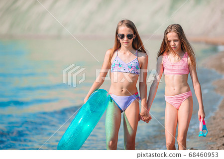 Adorable little girls having fun on the beach Adorable little girls having fun on the beach 68460953