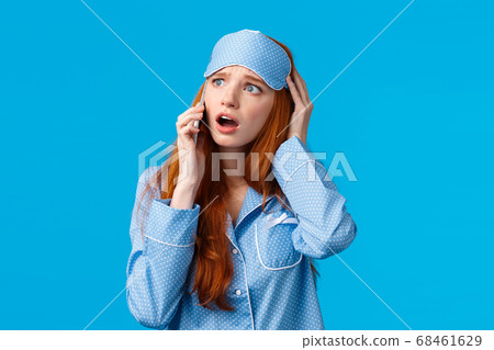 Alarmed and disappointed, upset redhead girl woke up bad news, calling friend telling bad dream via phonecall, holding smartphone near ear, talking look uneasy and anxious, blue background 68461629