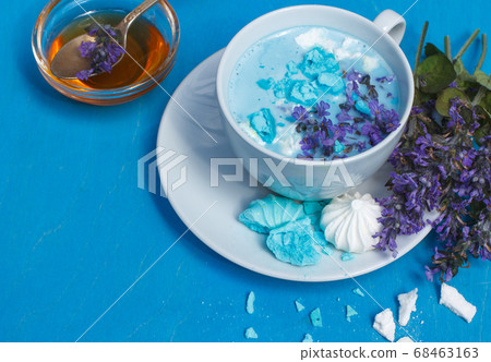 Blue moon milk decorated with mint flowers and meringue crumbs on a bright blue background Blue moon milk decorated with mint flowers and meringue crumbs on a bright blue background 68463163