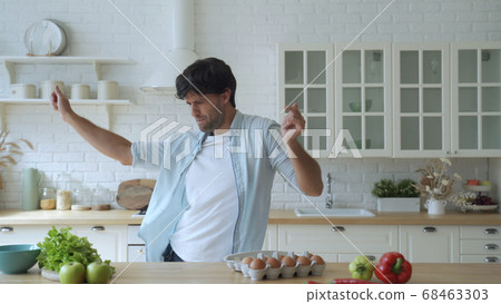 Young funny man dancing in kitchen at home in the morning 68463303