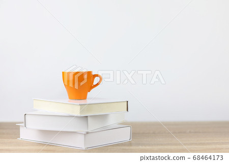 coffee cup with books on wooden desk and white background coffee cup with books on wooden desk and white background 68464173