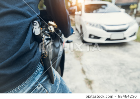 thief with gun on motorcycle trying to steal car (theft concept) 68464250
