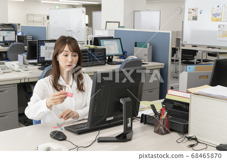 Young woman putting sticky notes on the edge of the monitor Young woman putting sticky notes on the edge of the monitor 68465870