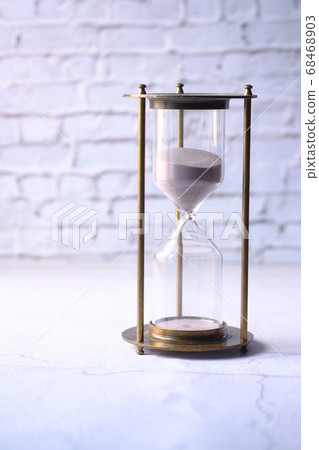 hourglass on table, sand flowing through the bulb of sandglass hourglass on table, sand flowing through the bulb of sandglass 68468903