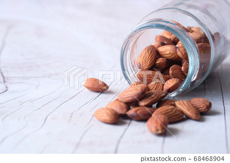 Close up of almond nut spilling from a container Close up of almond nut spilling from a container 68468904