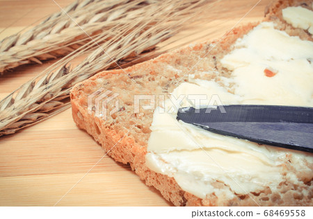 Slice of bread with butter and ears of wheat Slice of bread with butter and ears of wheat 68469558