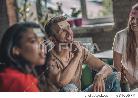 Friends playing a wording game with sticky notes 68469677