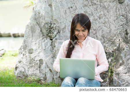 Asian woman sitting green park using laptop 68470663