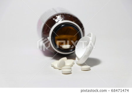 Pile of round white medicine on the floor. 68471474