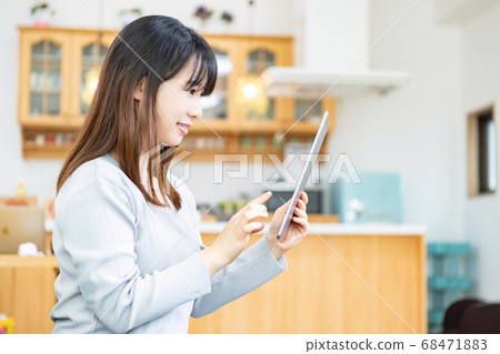 A young woman using a tablet terminal in the living room A young woman using a tablet terminal in the living room 68471883