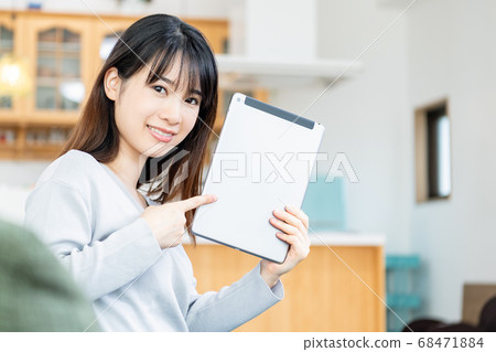 A young woman using a tablet terminal in the living room A young woman using a tablet terminal in the living room 68471884