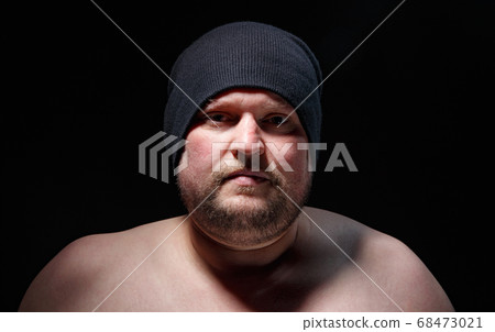 Portrait of fat man in cap with nude shoulders 68473021
