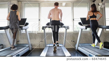 sporty caucasian people group in sportswear exercising with running machine in fitness gym 68474645