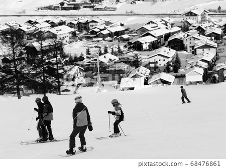 Skiers and snowboarder on snowy ski slope in high Skiers and snowboarder on snowy ski slope in high 68476861