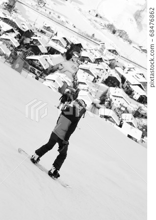 Snowboarders on snowy ski slope in high winter Snowboarders on snowy ski slope in high winter 68476862