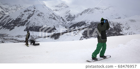 Group of snowboarders starts on off piste descent Group of snowboarders starts on off piste descent 68476957