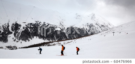Off-piste snowy ski slope with skiers in high Off-piste snowy ski slope with skiers in high 68476966