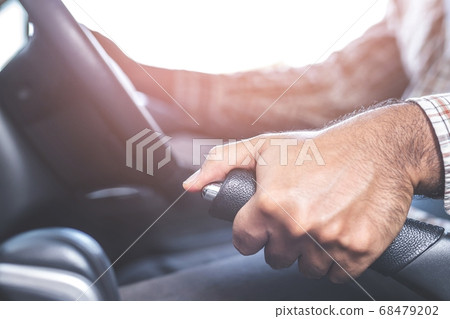 Male hand pulling a parking brake for safety Male hand pulling a parking brake for safety 68479202