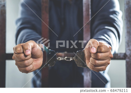 Handcuffed prisoner in jail 68479211