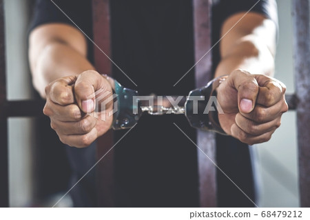 Handcuffed prisoner in jail 68479212