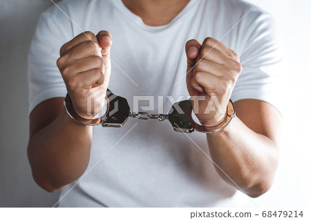 Handcuffed prisoner in jail 68479214