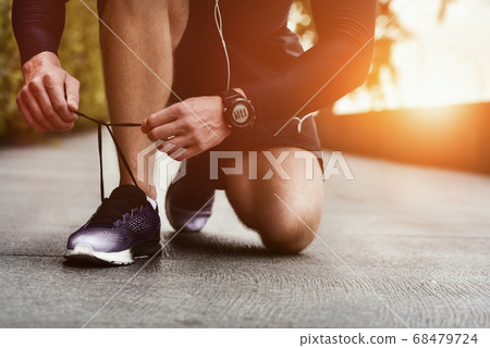 Close-up of sportsman tying sneakers. 68479724