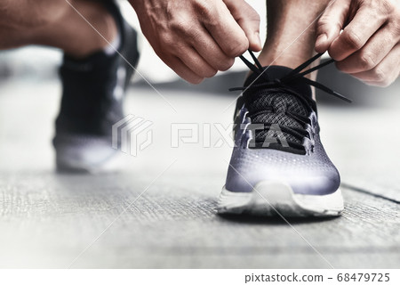 Close-up of sportsman tying sneakers. 68479725