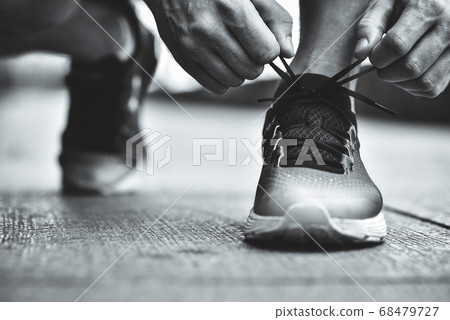 Close-up of sportsman tying sneakers. 68479727