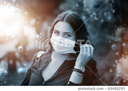 COVID 19 or SARS COV 2 social distancing women in city street. Young woman walks with surgical or protecting mask during pandemic 2020 68480293