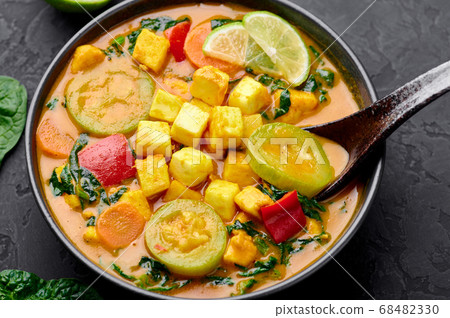 Yellow Veg Thai Curry with Tofu and vegetables in black bowl Yellow Veg Thai Curry with Tofu and vegetables in black bowl 68482330