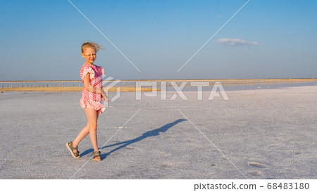 lady in a beautiful dress young with a beautiful smile against the backdrop of a salt lake during the day and in summer lady in a beautiful dress young with a beautiful smile against the backdrop of a salt lake during the day and in summer 68483180