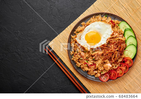 Nasi Goreng - Indonesian Chicken Fried Rice on black plate on slate table top Nasi Goreng - Indonesian Chicken Fried Rice on black plate on slate table top 68483664