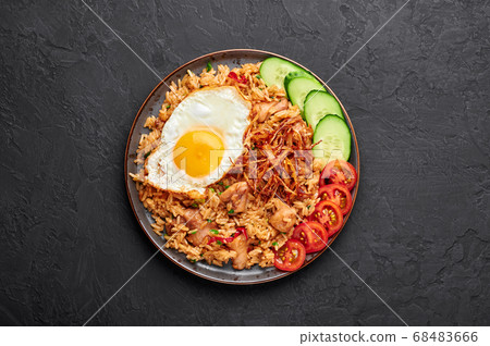 Nasi Goreng - Indonesian Chicken Fried Rice on black plate on slate table top Nasi Goreng - Indonesian Chicken Fried Rice on black plate on slate table top 68483666