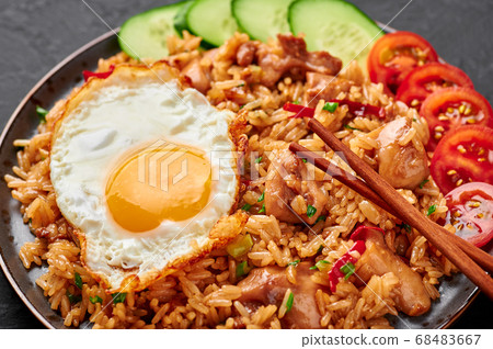 Nasi Goreng - Indonesian Chicken Fried Rice on black plate on slate table top Nasi Goreng - Indonesian Chicken Fried Rice on black plate on slate table top 68483667