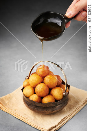 Loukoumades or luqaimat or lokma with syrup in vintage metal cup 68483691
