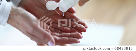 Lady applying antiseptic to clean hands 68483913