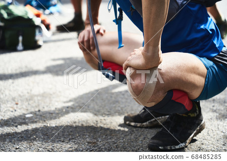 A male trail runner stretching before training. 68485285