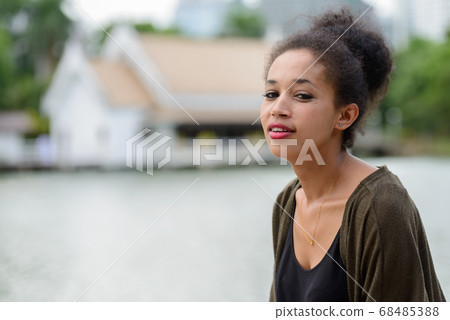Portrait of happy young beautiful African woman at the park Portrait of happy young beautiful African woman at the park 68485388