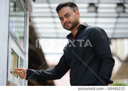 Young handsome bearded Indian businessman in the city 68486215