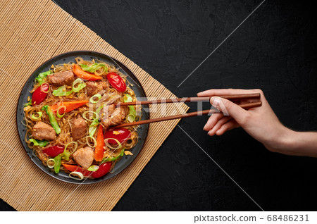 Pad Woon Sen or Thai Pork Glass Noodle Stir-Fry in black plate on dark slate backdrop 68486231
