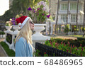 Girl in a red Christmas hat next to the swimming pool with blue water. Holiday concept. 68486965