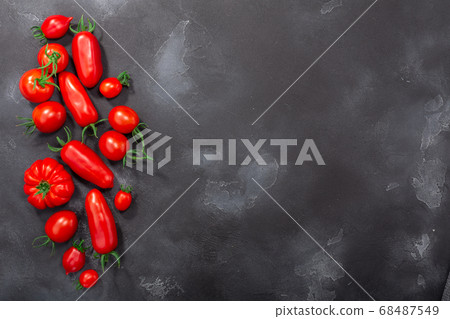 Red heirloom tomatoes on dark textured backdrop,  68487549