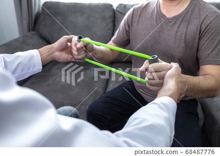 Doctor physiotherapist treating arm pain patient 68487776