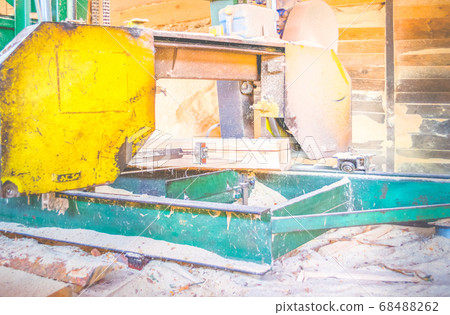 Sawmill. Process of machining logs in sawmill machine saws the tree trunk Sawmill. Process of machining logs in sawmill machine saws the tree trunk 68488262