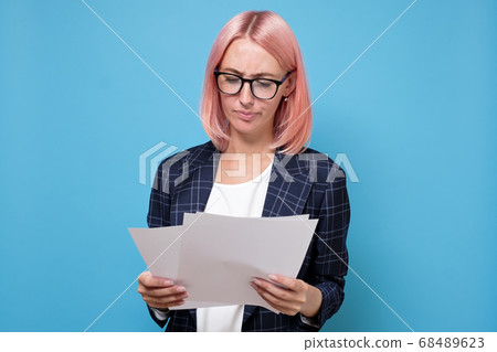 Young business woman with pink hair is analyzing business plan Young business woman with pink hair is analyzing business plan 68489623