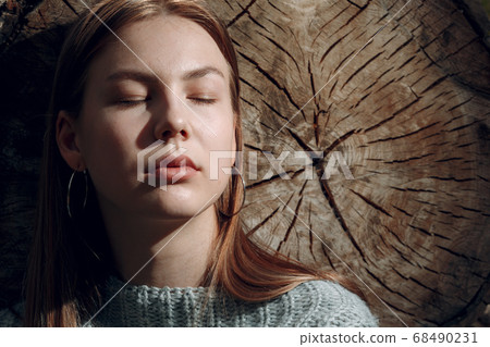 Pretty young woman at sawing tree outdoor in the park at summer. Pretty young woman at sawing tree outdoor in the park at summer. 68490231