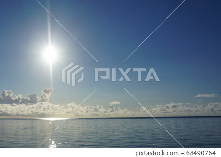 Glittering sun rising from the sea and water Glittering sun rising from the sea and water 68490764